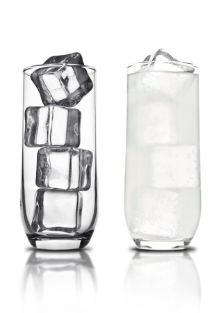 Glass of lemon lemonade with ice cubes and bubbles with reflection on white backgroundの写真素材