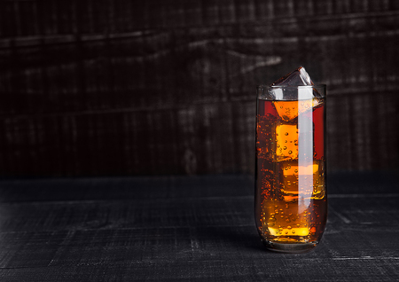 Glass of cola soda with ice cubes on wooden board backgroundの写真素材