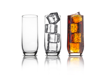 Glass of cola with ice cubes and empty glassess  and bubbles reflection on white backgroundの写真素材