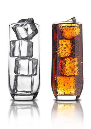 Glass of cola with ice cubes and empty glass  and bubbles reflection on white backgroundの写真素材