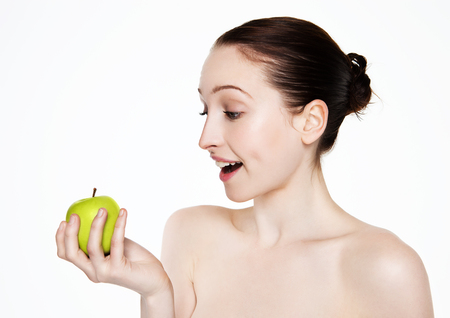 Beautiful fitness woman holding healthy apple on white backgroundの写真素材