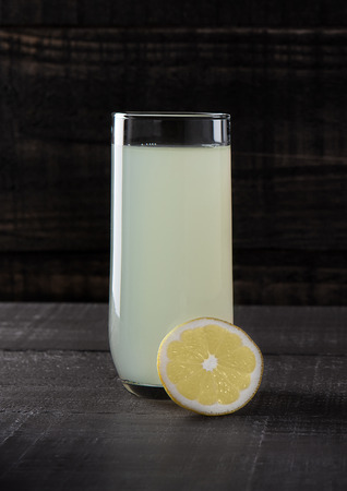 Glass of healthy lemon lemonade juice with fruit on wooden backgroundの写真素材