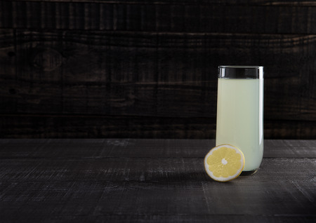 Glass of healthy lemon lemonade juice with fruit on wooden backgroundの写真素材