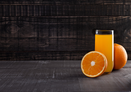 Glass of healthy orange juice with fruit on wooden backgroundの写真素材