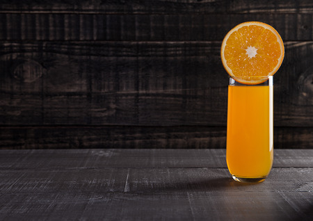 Glass of healthy orange juice with fruit on wooden backgroundの写真素材