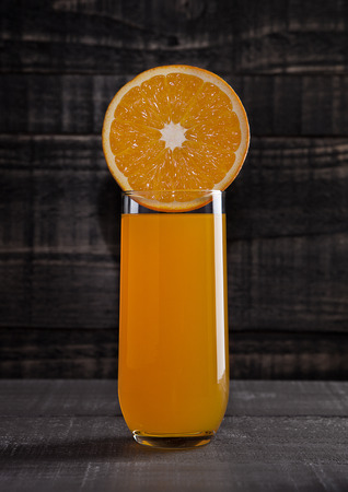 Glass of healthy orange juice with fruit on wooden backgroundの写真素材