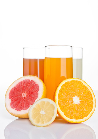 Glasses of healthy grapefruit and orange and lemon juice on white backgroundの写真素材