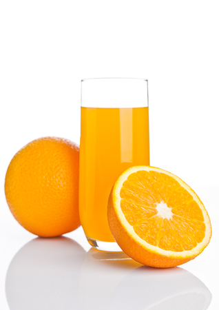 Glass of healthy orange juice with fruit on white backgroundの写真素材