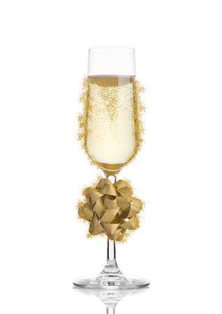 Glass of champagne with christmas decoration gift on white isolatedの写真素材