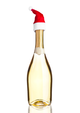Bottle of yellow champagne with santa hat on white backgroundの写真素材
