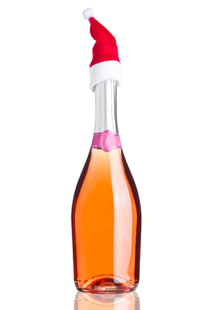 Bottle of pink rose champagne with santa hat on white backgroundの写真素材