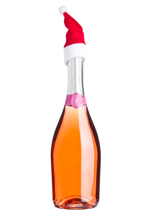 Bottle of pink rose champagne with santa hat on white backgroundの写真素材