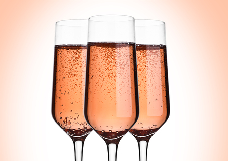 Glass of pink rose champagne with bubbles on pink backgroundの写真素材