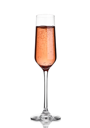 Glass of pink rose champagne with bubbles on white background with reflectionの写真素材
