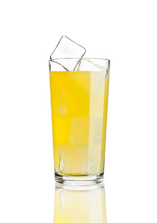 Glass of orange soda drink cold with ice cubes on white background with reflectionの写真素材