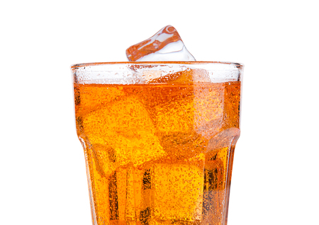 Glass of orange energy soda drink with ice on white backgroundの写真素材