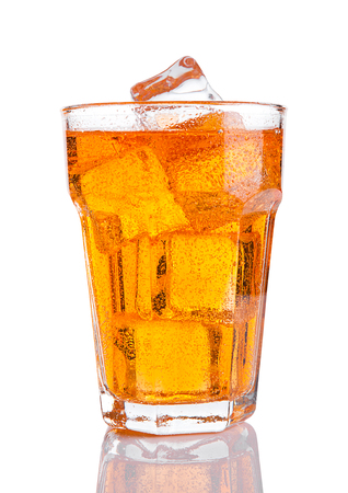 Glass of orange energy soda drink with ice on white backgroundの写真素材