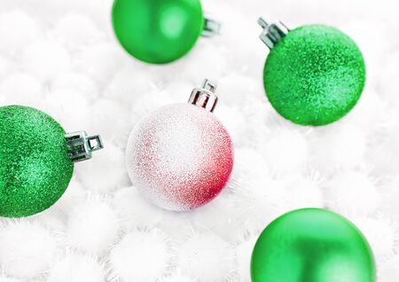 Green christmas ball on snow balls on white backgroundの写真素材
