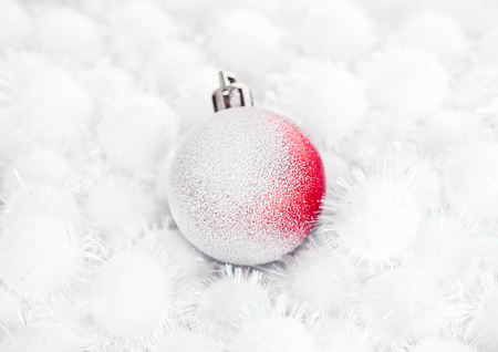 Red christmas ball on snow balls on white backgroundの写真素材
