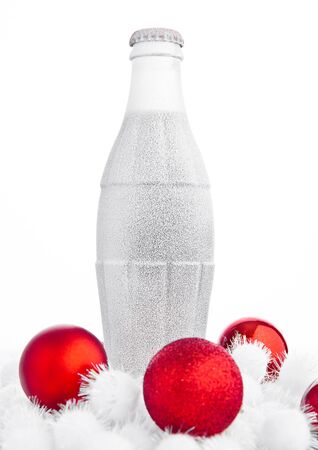 Bottle of cola with frost snow and christmas toys on white backgroundの写真素材