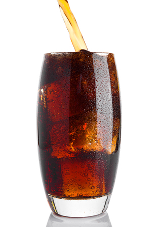 Pouring cola soda drink into the glass with ice on white backgroundの写真素材