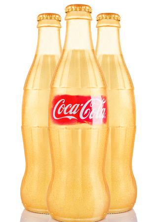 LONDON, UK - NOVEMBER 07, 2016: Golden classic bottles of Coca-cola with logo on white backgroundのeditorial素材