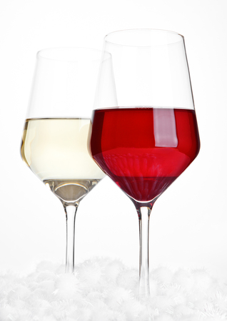Glasses of red and white wine christmas with balls on white backgroundの写真素材