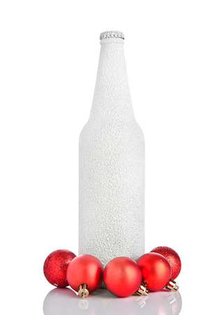Cold beer bottle covered with snow christmass ball on white background with reflectionの写真素材