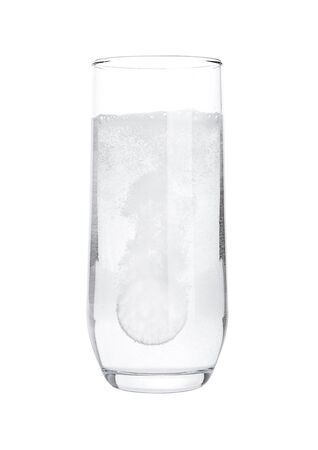 Pill dissolving in glass of water on white background isolatedの写真素材