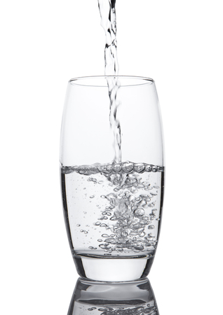 Pouring cold fresh healthy still water to glass on white backgroundの写真素材