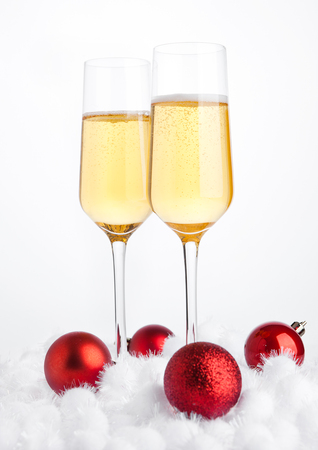 Glasses of champagne with bubbles on snow on white backgroundの写真素材