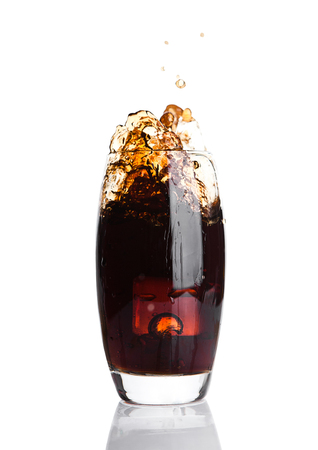 Glass of cola with splash and ice cubes on white backgroundの写真素材