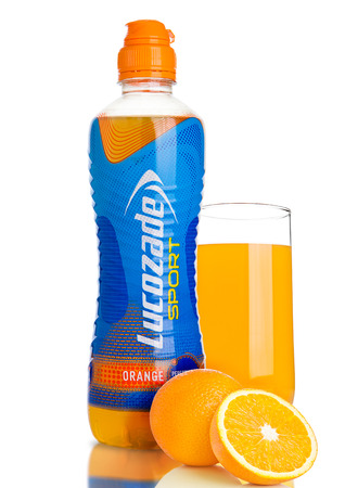 LONDON, UK - NOVEMBER 11, 2016: Cold bottle of Lucozade Sport energy drink with orange and glass on white background with reflectionのeditorial素材