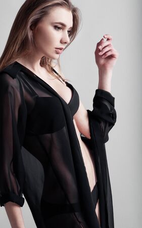 Beautiful sexy woman with black lingerie on grey backgroundの写真素材