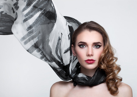 Beautiful girl with grey fashion scarf on grey backgroundの写真素材