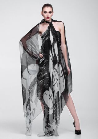 Beautiful girl with grey fashion scarf on grey backgroundの写真素材