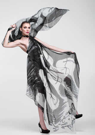 Beautiful girl with grey fashion scarf on grey backgroundの写真素材