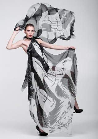Beautiful girl with grey fashion scarf on grey backgroundの写真素材