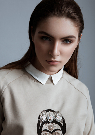 Beautiful fashion model wearing grey jumper skull in studioの写真素材