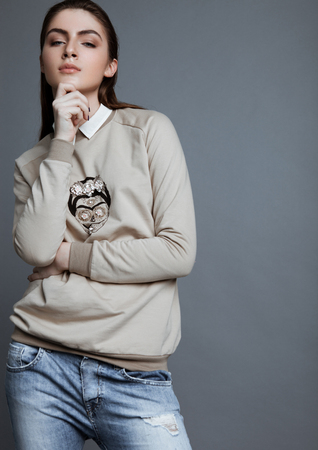 Beautiful fashion model wearing grey jumper skull in studioの写真素材