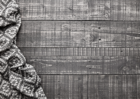 Warm soft wool scarf on wooden background texture. Autumn moodの写真素材