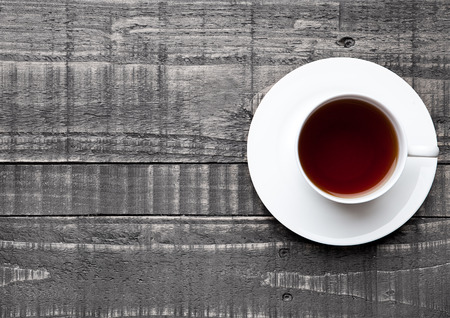 Cup of black healthy tea on wooden backgroundの写真素材