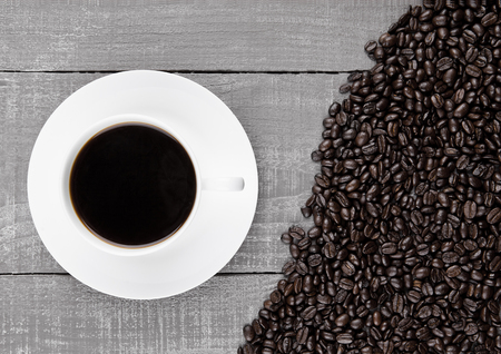 Cup of black  coffee for breakfast with beans on coffee beans backgroundの写真素材