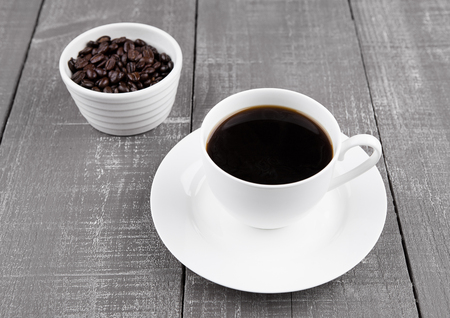 Cup of black  coffee for breakfast with beans on wooden backgroundの写真素材