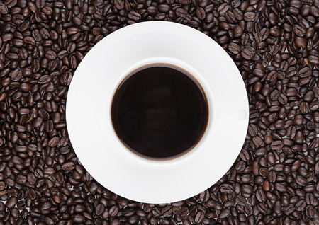 Cup of black  coffee for breakfast with beans on coffee beans backgroundの写真素材