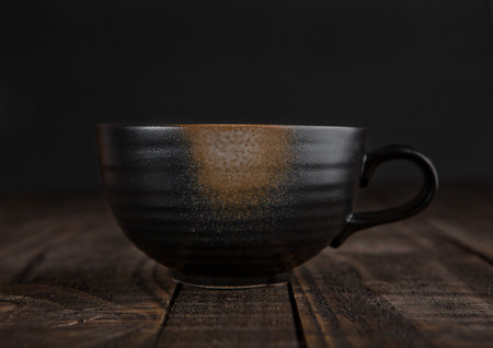 Large cup with hot cappuccino with coffee beans on wooden boardの写真素材