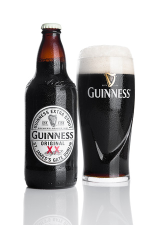 LONDON, UK - NOVEMBER 29, 2016: Guinness extra stout beer bottle and glass on white background. Guinness beer has been produced since 1759 in Dublin, Ireland.のeditorial素材