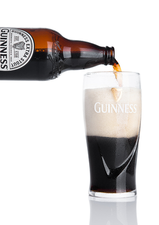 LONDON, UK - NOVEMBER 29, 2016: Guinness extra stout beer bottle on white background. Guinness beer has been produced since 1759 in Dublin, Ireland.のeditorial素材