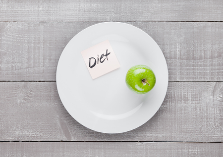 Healthy diet with fresh organic apple on the plate on wooden boardの写真素材