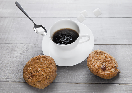 Cup of fresh coffee with cookies and sugar for breakfast on wooden boardの写真素材